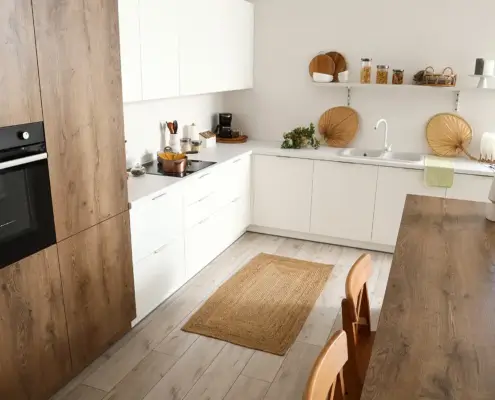 Cocina estilo escandinavo con muebles blancos y acabados en madera clara, ejemplo de diseño natural y minimalista para el hogar en 2026